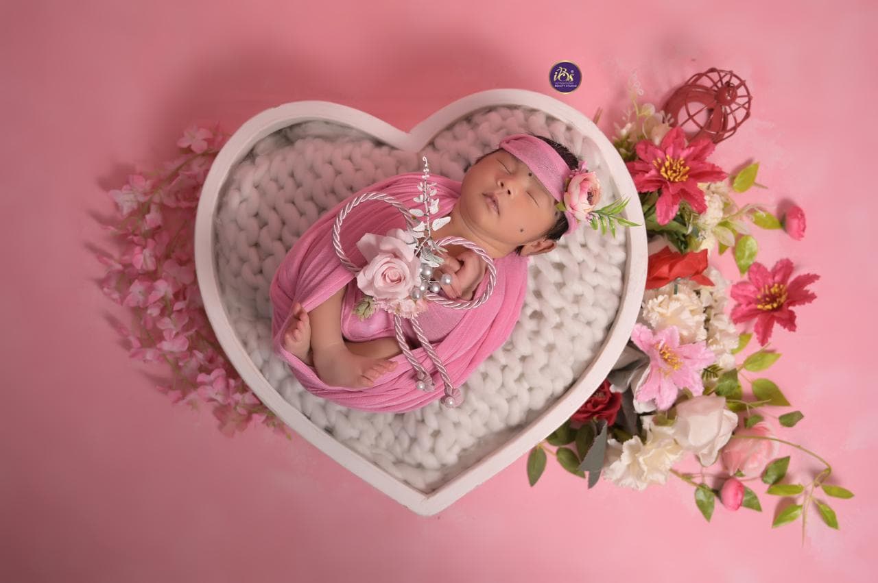 Baby portrait with soft background and expressive pose at IBS Baby Photoshoot studio in Karvenagar, Pune